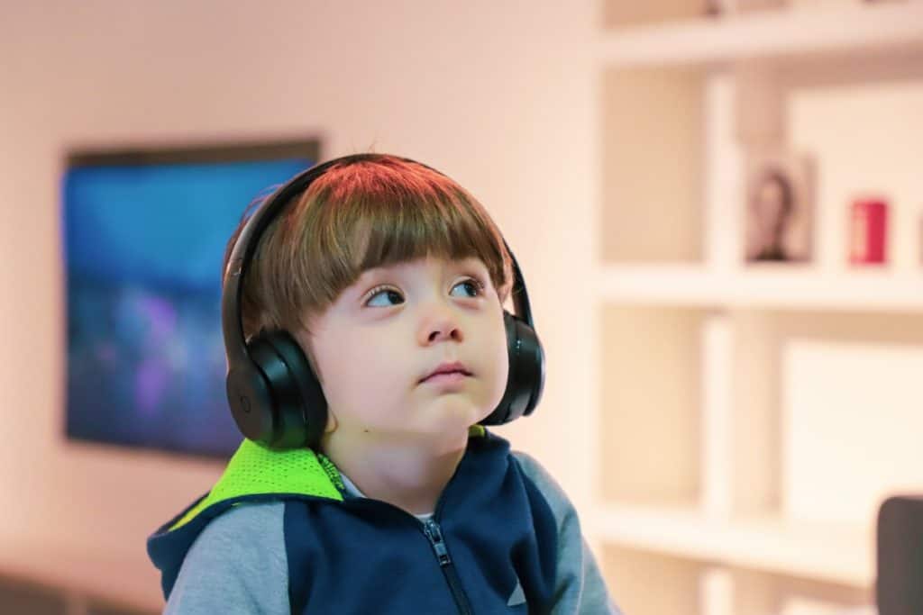 toddler wearing noise-cancelling headphones looking up