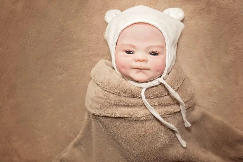 lifelike baby doll wrapped in blanket